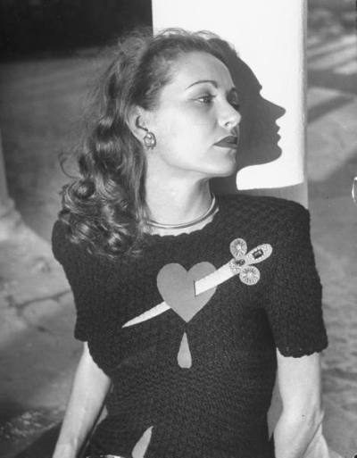 retrozone: extranuance: my-ear-trumpet: gh2u: mudwerks: suyhnc: badminton: zasu: Model wearing sweater with heart pierced by jeweled dagger. (1947) Photo by Nina Leen for LIFE
