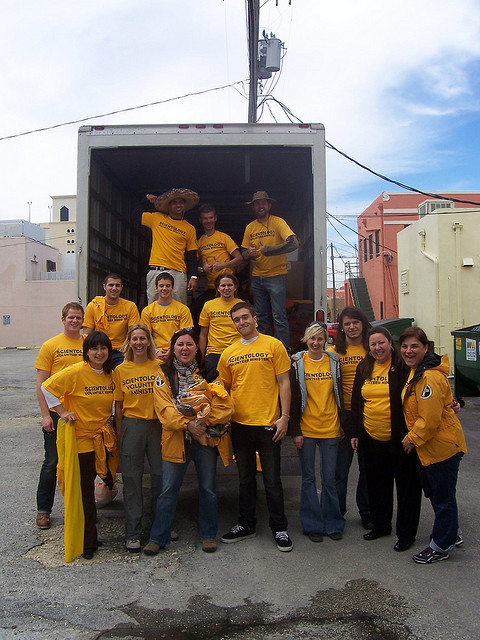 Scientology Volunteer Ministers stand proudly in front of a truck loaded with supplies for Haiti.