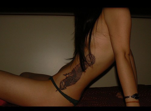 Feather tattoo on woman's sexy side Source whiiteknights 