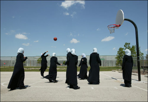 women wearing hijabs playing basketball